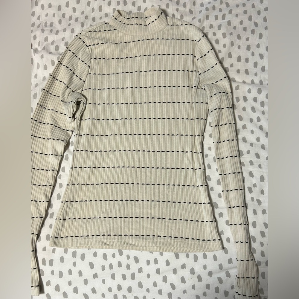 Small turtle neck white black dotted long sleeve shirt.